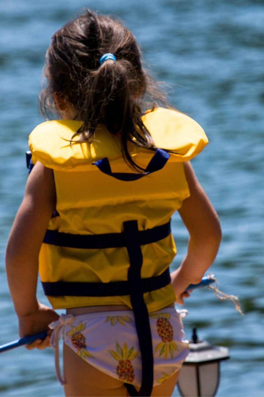 girl wearing life vest at the beach
