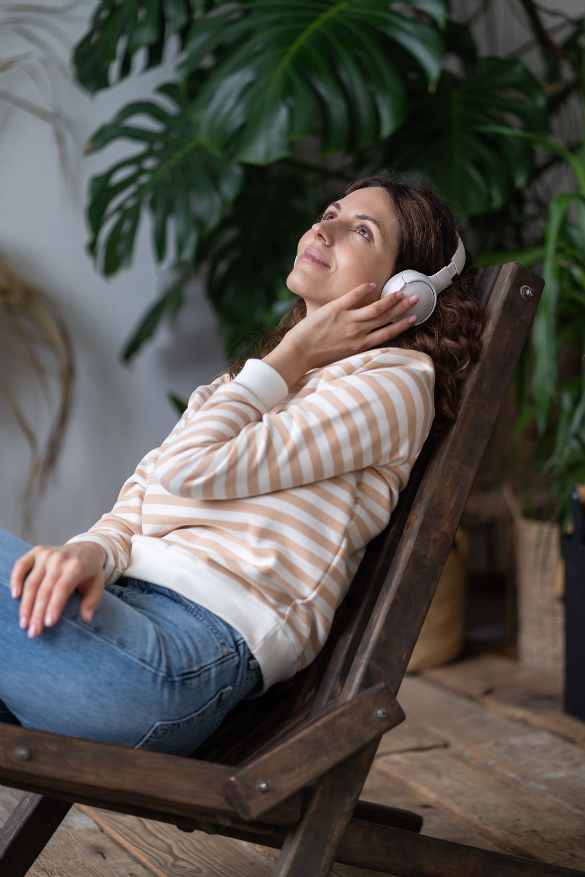 webserene-woman-in-earphones-rest-in-greenhouse-relax-2022-11-15-05-12-38-utc